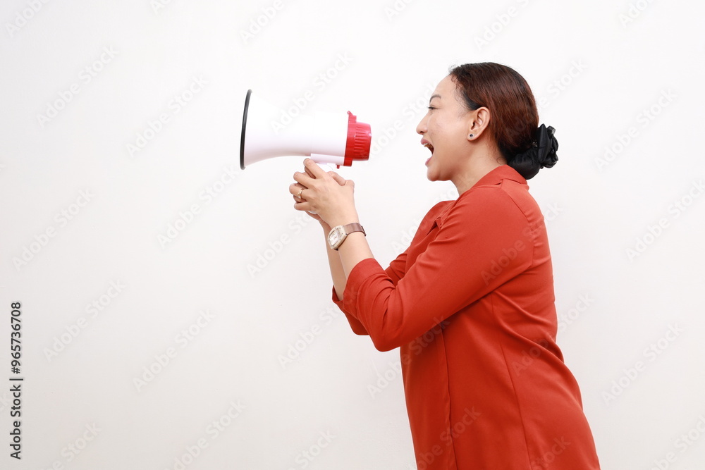 Happy beautiful Asian woman talking on megaphone to sideways isolated on white background Happy beautiful Asian woman talking on megaphone to sideways isolated on white background