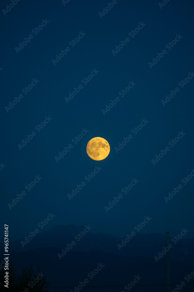 Big yellow moon rising above foggy mountains Big yellow moon rising above foggy mountains