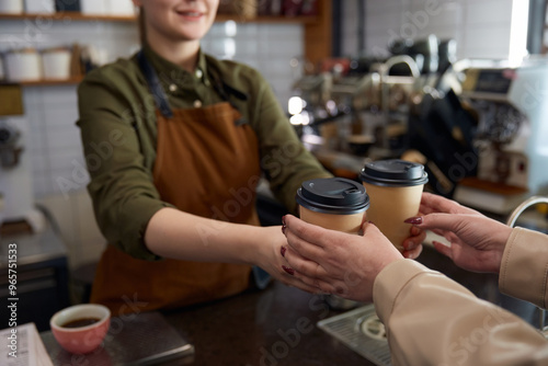 Obraz na płótnie Woman barista serving coffee in takeaway paper cups w salonie