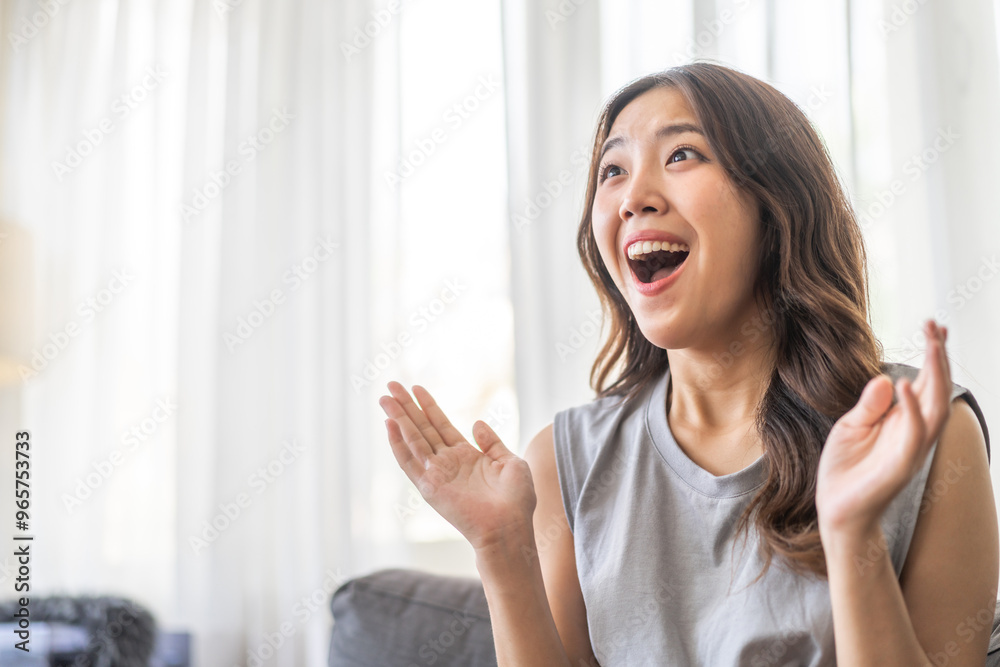 Excited asian woman expressing joy at home, cheerful and happy facial expression, positive emotions, surprised female reaction, happiness and delight, lifestyle, young woman celebrating good news Excited asian woman expressing joy at home, cheerful and happy facial expression, positive emotions, surprised female reaction, happiness and delight, lifestyle, young woman celebrating good news