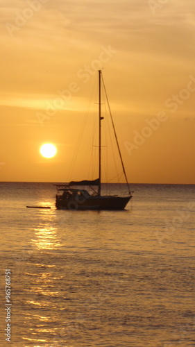 Derrière le bateau, le soleil se couche sur la mer