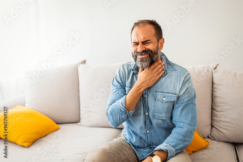 Man Experiencing Sore Throat While Sitting on a Sofa