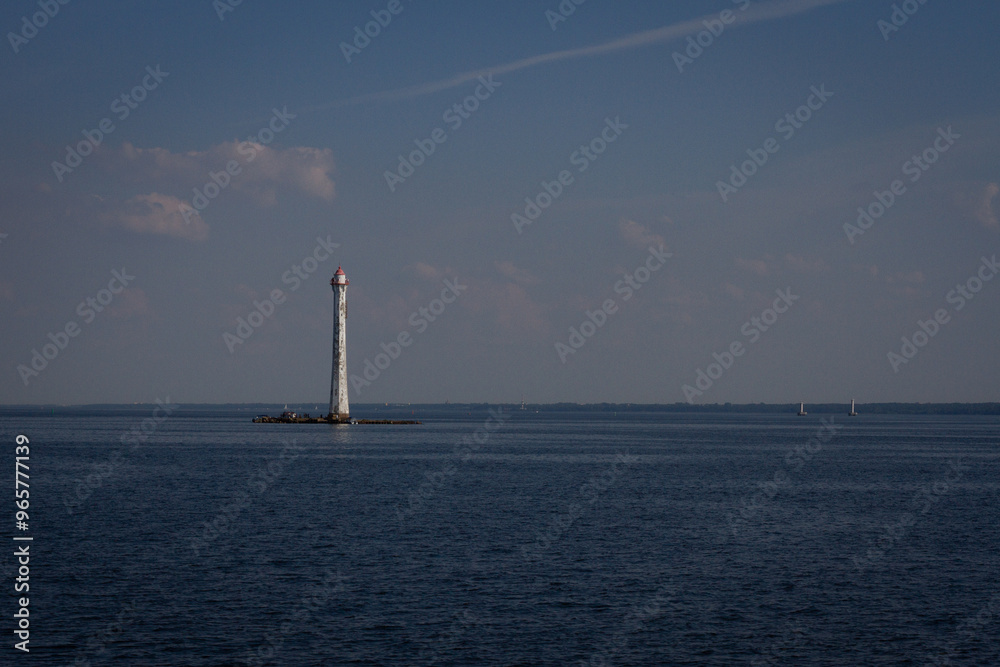 View of the lighthouse and the sea illuminated by the sun and clouds View of the lighthouse and the sea illuminated by the sun and clouds