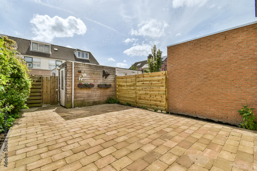 Suburban home backyard with wooden fence and paving Suburban home backyard with wooden fence and paving