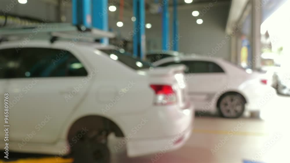 Blurred video of car repair garage with white vehicles on hydraulic lifts, demonstrating maintenance and automotive services. Auto Repair and Vehicle Maintenance. Blurred video of car repair garage with white vehicles on hydraulic lifts, demonstrating maintenance and automotive services. Auto Repair and Vehicle Maintenance.
