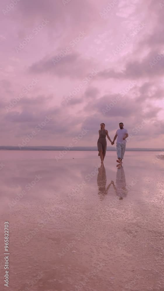 custom made wallpaper toronto digitalCouple enjoying peaceful walk on beach, hand in hand, during stunning pastel sunset. Reflective sand enhances romantic atmosphere. Vertical video