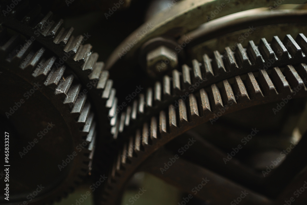 Fototapeta premium Two gears are shown in close up, one of which is missing a tooth. Concept of wear and tear, as the gears appear to be old and rusty. The close-up view emphasizes the details of the gears