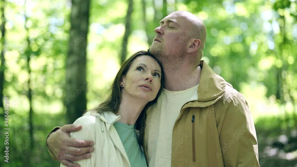 The second couple holds hands while walking, both in light jackets. The woman looks at the wildflowers, and the man smiles, clearly enjoying this quiet walk. The second couple holds hands while walking, both in light jackets. The woman looks at the wildflowers, and the man smiles, clearly enjoying this quiet walk.
