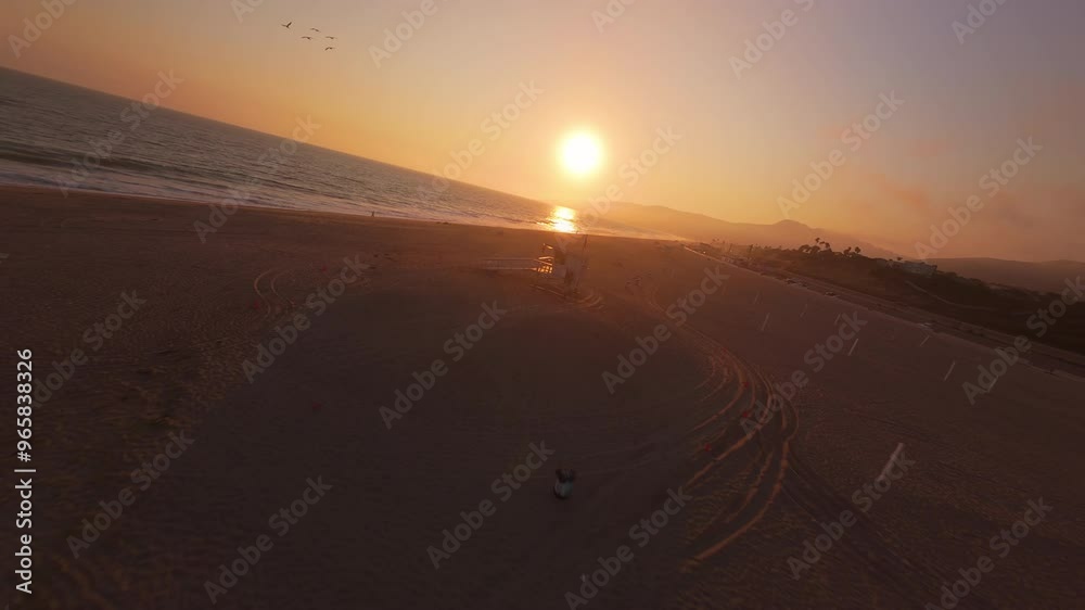 A stunning firstpersonview FPV drone captures a breathtaking and colorful sunset in Malibu, California, as it gracefully follows seagulls gliding along the picturesque shoreline of the coast A stunning firstpersonview FPV drone captures a breathtaking and colorful sunset in Malibu, California, as it gracefully follows seagulls gliding along the picturesque shoreline of the coast