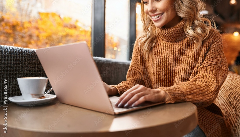 Smiling woman working on laptop in cozy cafe with coffee, daytime, casual autumn attire, productivity and relaxation concept Smiling woman working on laptop in cozy cafe with coffee, daytime, casual autumn attire, productivity and relaxation concept