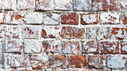 Ancient ruined brick wall with paint residue. Brick weathering. Selective focus