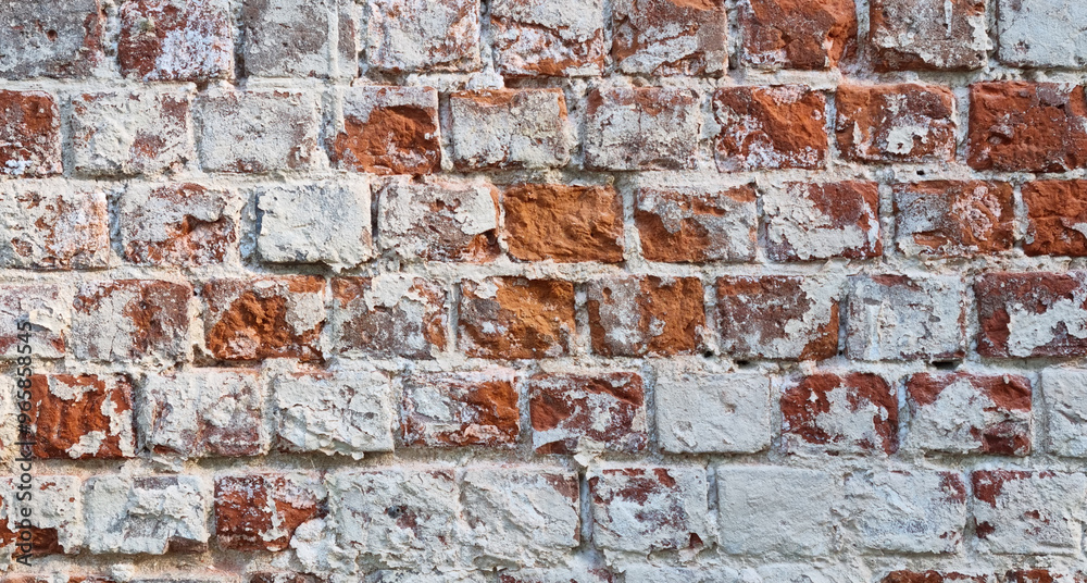 Ancient ruined brick wall with paint residue. Brick weathering. Selective focus Ancient ruined brick wall with paint residue. Brick weathering. Selective focus