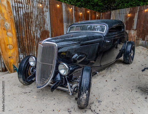 Φωτογραφία Black street rod style American classic car. at the beach.