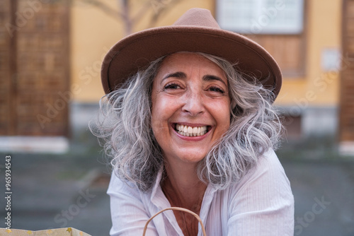 50 year old woman with gray hair smiling on a shopping day. Concept: happy, smile
