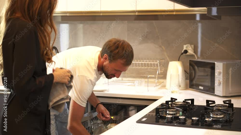 Couple Cleaning Kitchen and Loading Dishwasher While Chatting Couple Cleaning Kitchen and Loading Dishwasher While Chatting