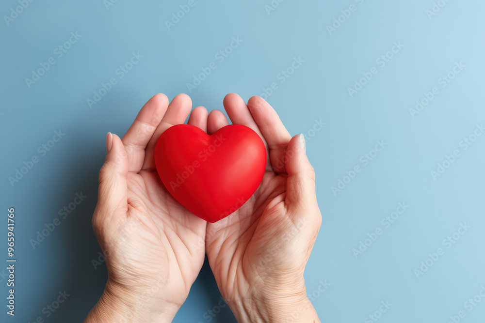 Red heart in woman's hand support on aging a blue background for promoting health care campaign concept, Heart day, Hear attact, Valentine's day Red heart in woman's hand support on aging a blue background for promoting health care campaign concept, Heart day, Hear attact, Valentine's day