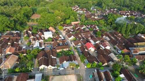 Aerial view small beautiful village in Indonesia. Terbang di atas rumah dan jalanan sebuah desa kecil di Indonesia menggunakan drone. 4k drone footage