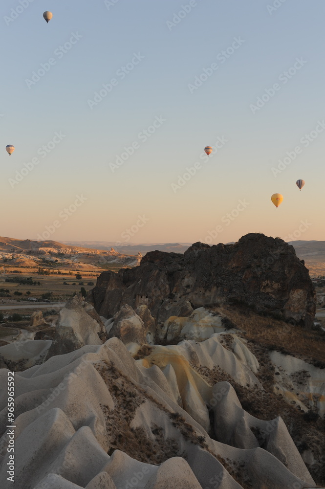 Fototapeta premium Beautiful view of hot air balloons floating in the air at sunrise with clear sky in Cappadocia, Turkey (Türkiye)