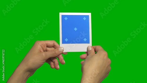 Holding Instant Photo Frame in Hands Evaluating and Considering photo