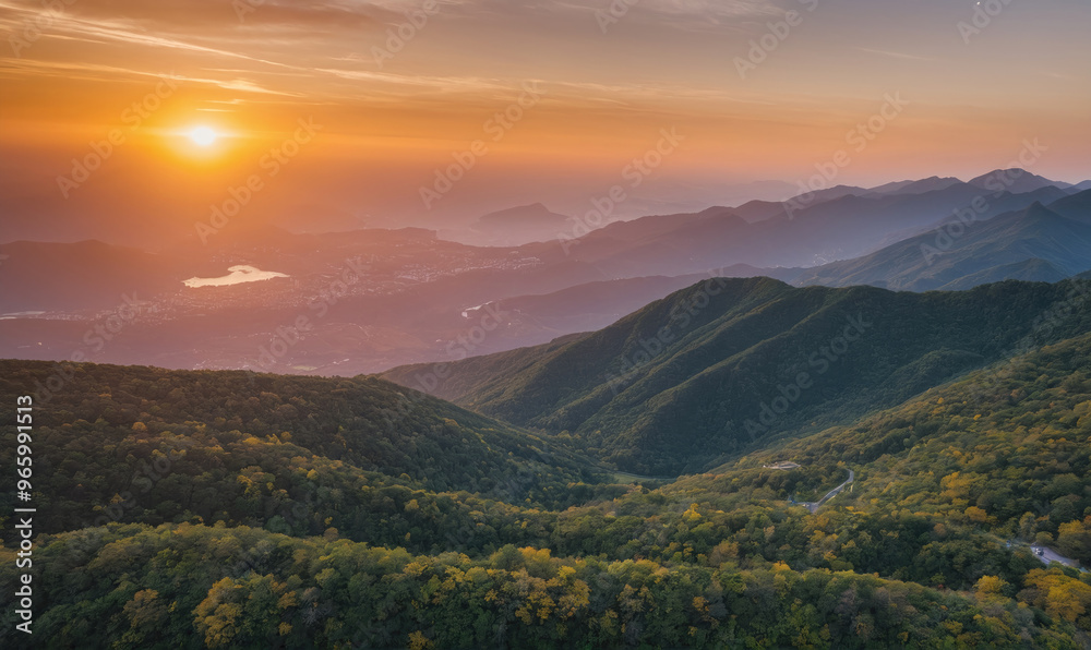 Naklejka premium A beautiful mountain range with a sun setting in the background