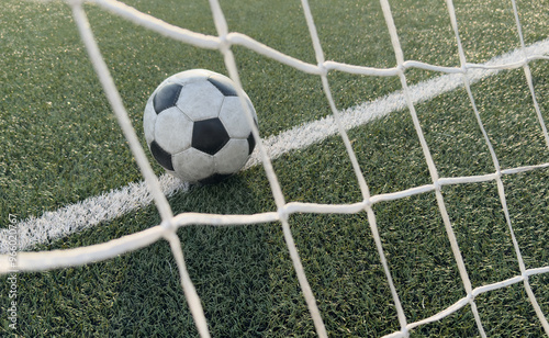 Soccer ball in goal on blue background
