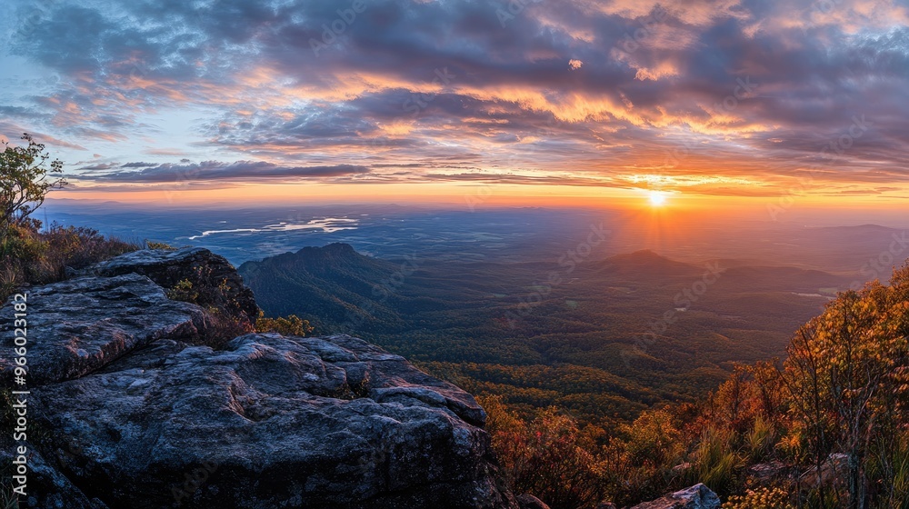 Panoramic view of a sunrise atop a famous mountain, highlighting the changing colors of the sky and distant landscapes. Panoramic view of a sunrise atop a famous mountain, highlighting the changing colors of the sky and distant landscapes.