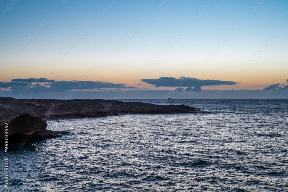 The sky is a beautiful shade of orange and the water is calm. The scene is peaceful and serene The sky is a beautiful shade of orange and the water is calm. The scene is peaceful and serene