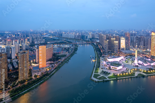 Vibrant Cityscape at Dusk - Aerial View Over Urban River