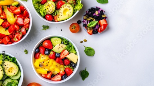 A white bowl of fruit salad is placed on a table. The bowl contains a variety of fruits such as strawberries, blueberries, and bananas. The salad is arranged in a visually appealing manner