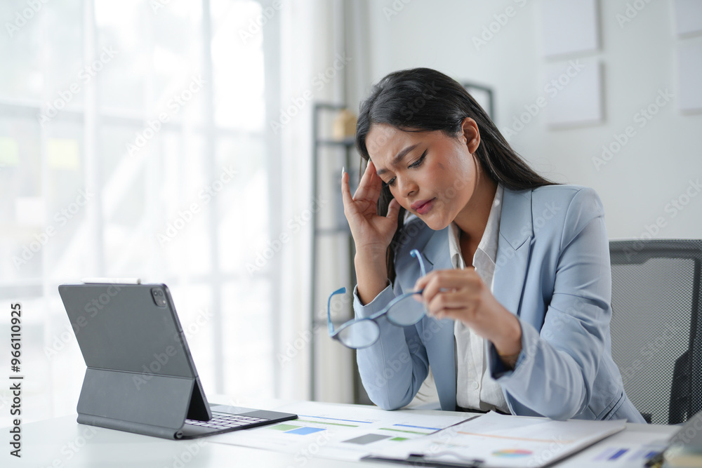 Stressed businesswoman suffering headache working using laptop computer at office Stressed businesswoman suffering headache working using laptop computer at office