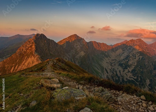 Mountain trail leading along the mountain ridge of beautiful mountains with autumn grass and colorful sky. Western Tatras, High Tatras, Slovakia, Poland. Discovering hiking in a colorful autumn.