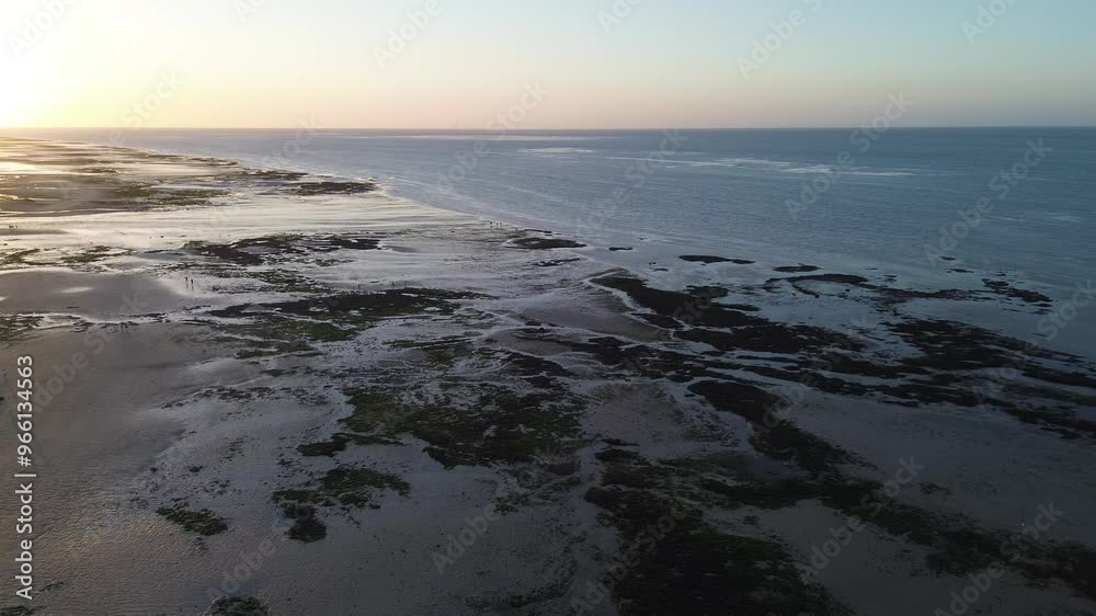 Panoramic travel shot of a Normandy beach at low tide during a sunset Panoramic travel shot of a Normandy beach at low tide during a sunset