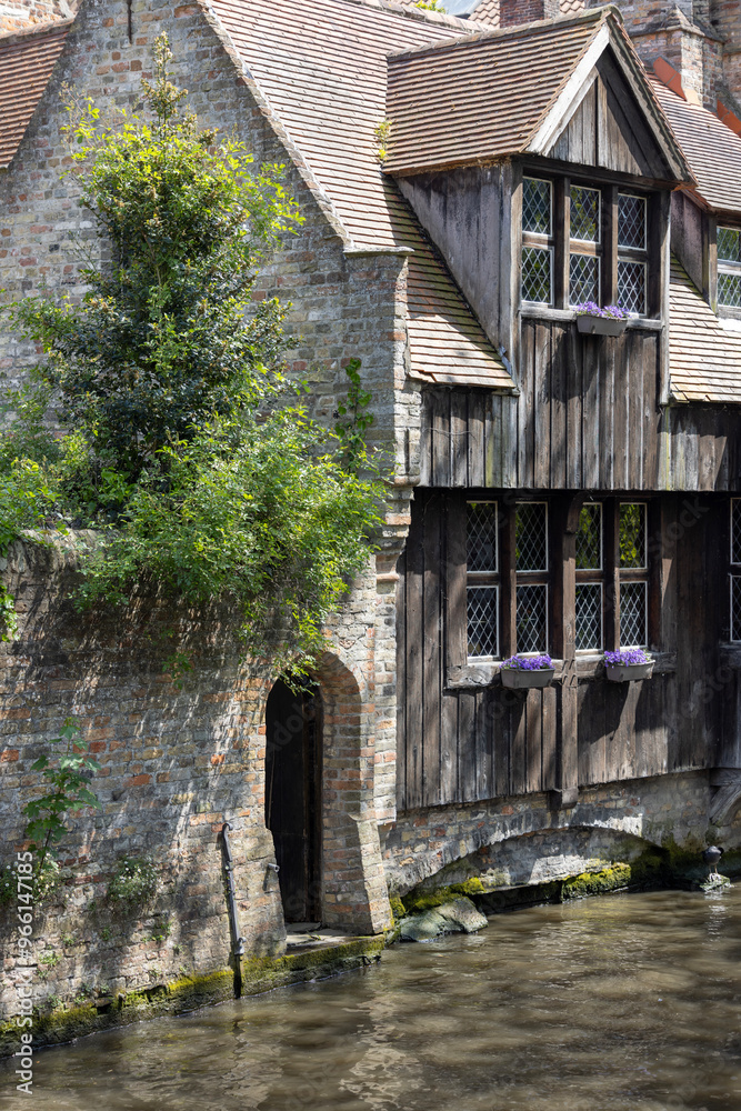 Picturesque view of water channels of the city near Beguinage Houses (Begijnhof), Bruges, Belgium