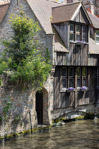 Picturesque view of water channels of the city near Beguinage Houses (Begijnhof), Bruges, Belgium