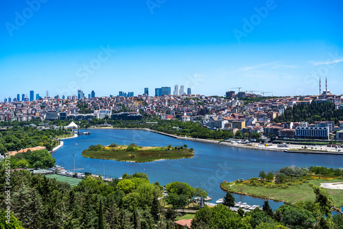 Türkiye. Istanbul. Panoramic view of the Golden Horn with its green banks, buildings and skyscrapers in the background under a sunny blue sky