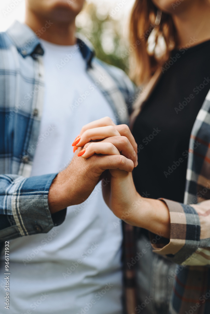 couple holding hands, young beautiful caucasian man and woman take each other hands, dressed in checkered shirts, standing in park in summer, love and family concept, cropped image couple holding hands, young beautiful caucasian man and woman take each other hands, dressed in checkered shirts, standing in park in summer, love and family concept, cropped image