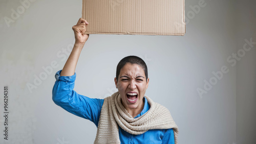 Arab Short Hair Woman Holding Up An Empty Cardboard Sign And Screaming. Politics, Protest And Discontent Concept photo