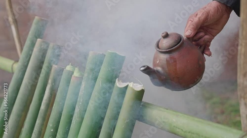 The process of making lemang, a food that is quite well-known in Malaysia and Indonesia. A man is making lemang, a food made from sticky rice that is put into bamboo lined with banana leaves