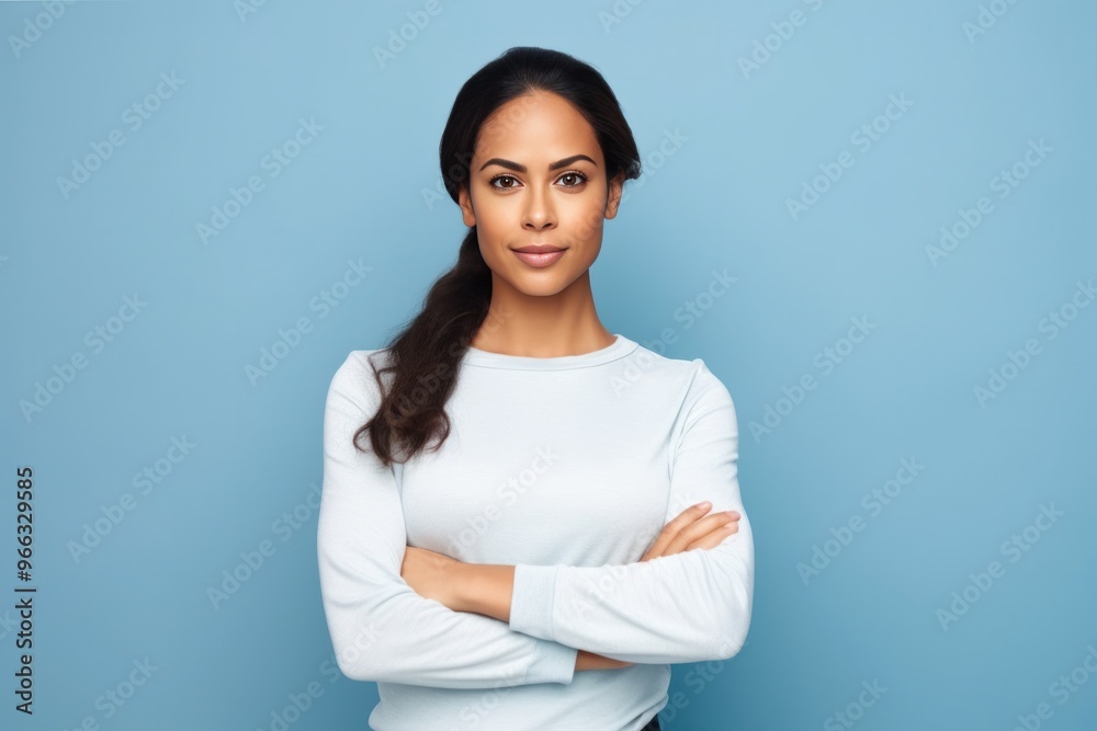 Woman posing with arms crossed on blue background Woman posing with arms crossed on blue background