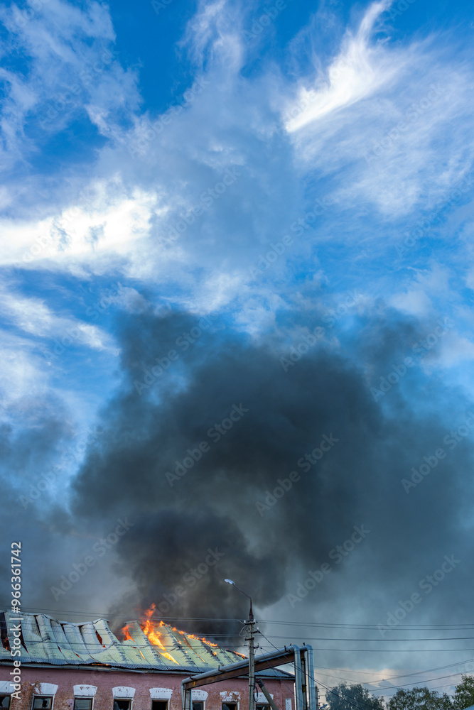 Fototapeta premium A fire is burning on the roof of a building
