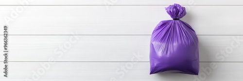 A single purple trash bag hangs on a white wooden background. This image is perfect for representing cleanliness, hygiene, and waste disposal. It can also symbolize a fresh start, a clean slate, or a  photo