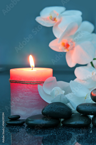 Spa background with white orchid , candle and zen black stones .