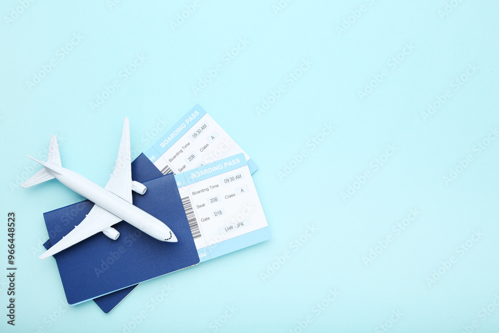 Passports with boarding passes and airplane model on blue background