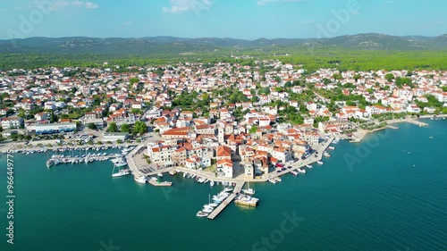 An aerial view of Pirovac Marina in Croatia, showcasing a stunning collection of yachts docked along the beautiful Adriatic coastline. The marina, surrounded by crystal-clear waters and picturesque  photo