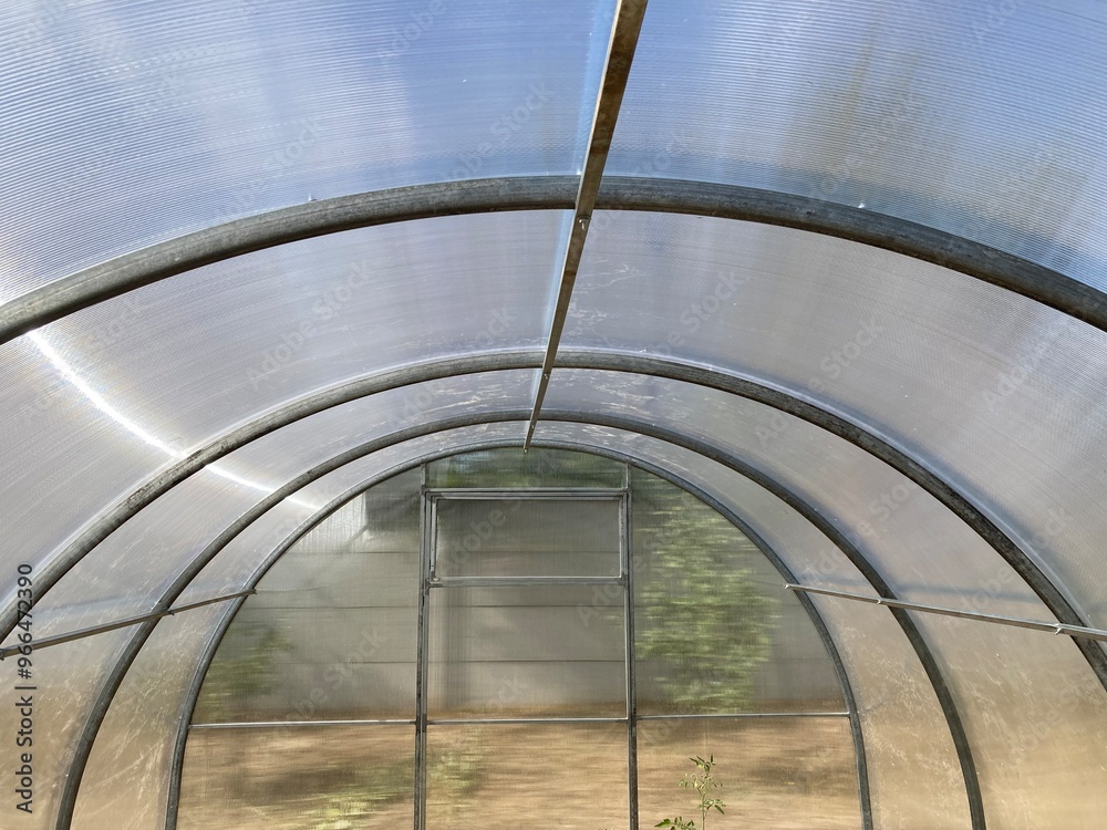 Fototapeta premium Installation of a metal frame greenhouse with polycarbonate covering