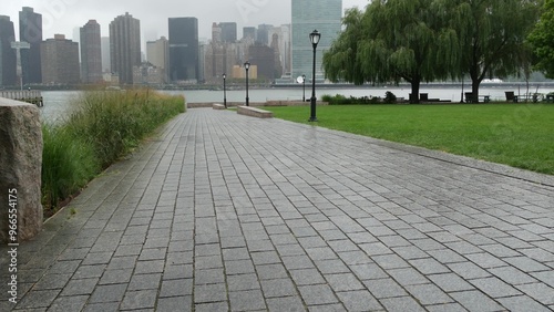 New York City waterfront skyline, Manhattan Midtown buildings, riverfront skyscrapers by East river water. Waterside cityscape rainy foggy view, Gantry Plaza Park, Long Island, Queens, United States. photo