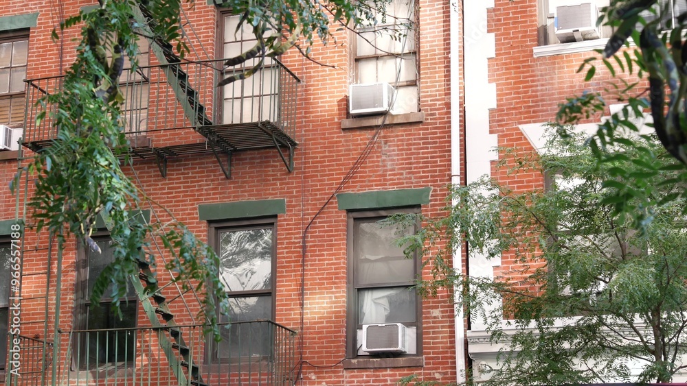 Naklejka premium New York City classic building architecture, Manhattan, USA. Urban residential house exterior. Real estate property in United States. Typical red brick facade. Fire escape, emergency ladder exit.