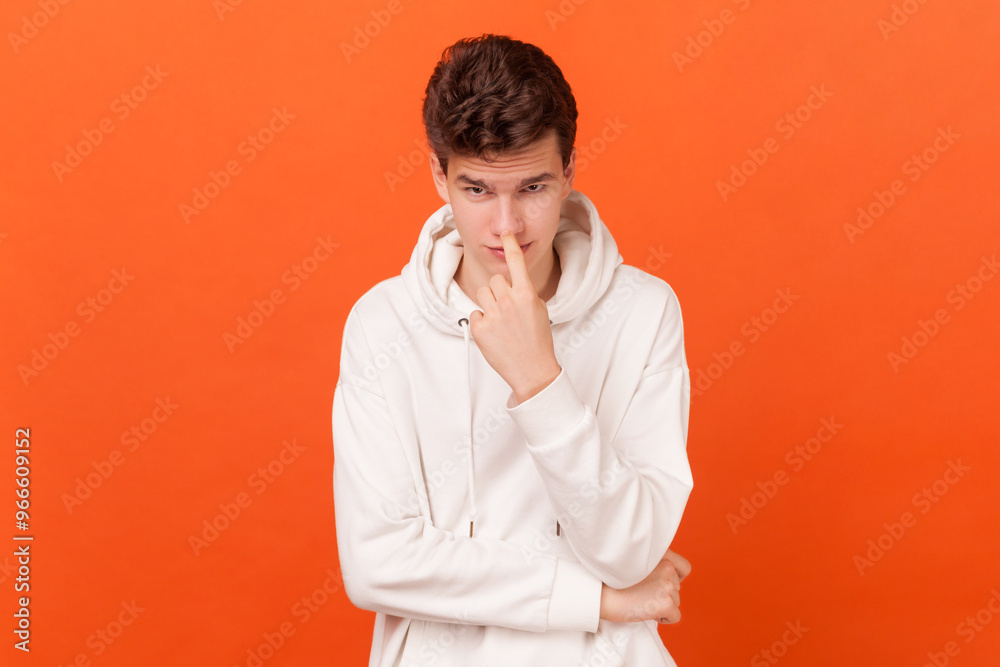 You lie. Portrait of young man wearing white hoodie looking at camera and pointing at his nose, saying to trickster you are liar, body language. Indoor studio shot isolated on orange background. You lie. Portrait of young man wearing white hoodie looking at camera and pointing at his nose, saying to trickster you are liar, body language. Indoor studio shot isolated on orange background.