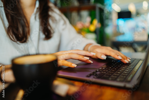 Young caucasian woman working or studying on laptop from cafe 