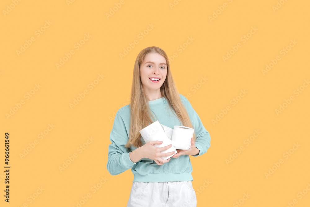 Fototapeta premium Young woman with toilet paper rolls against color background